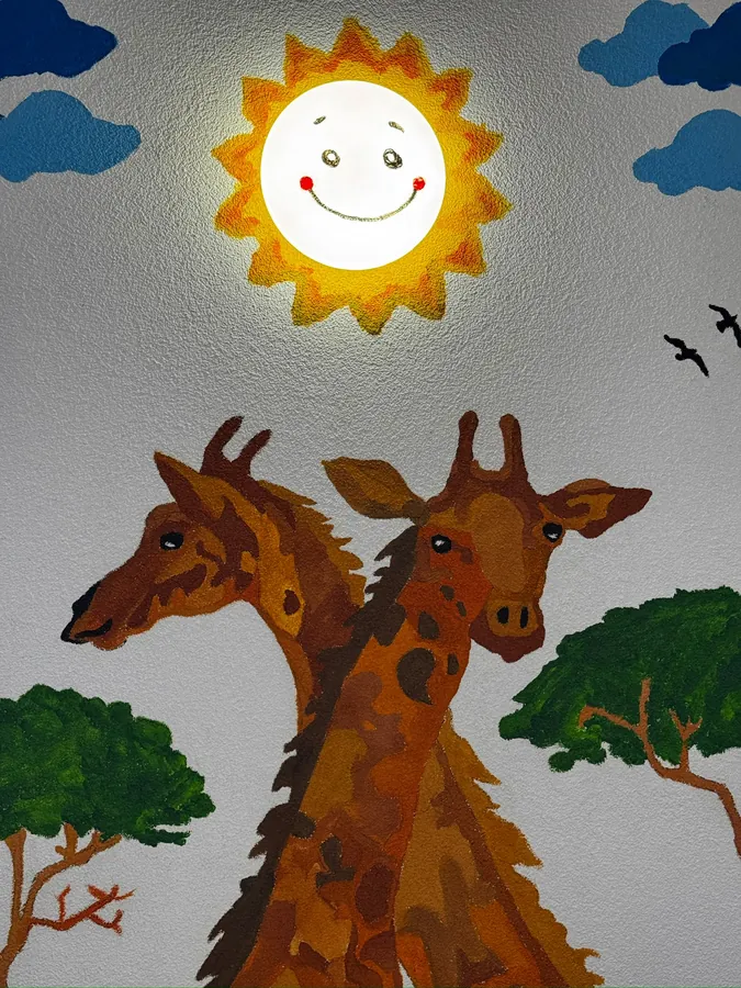 Ručne maľované žirafy na stene herne